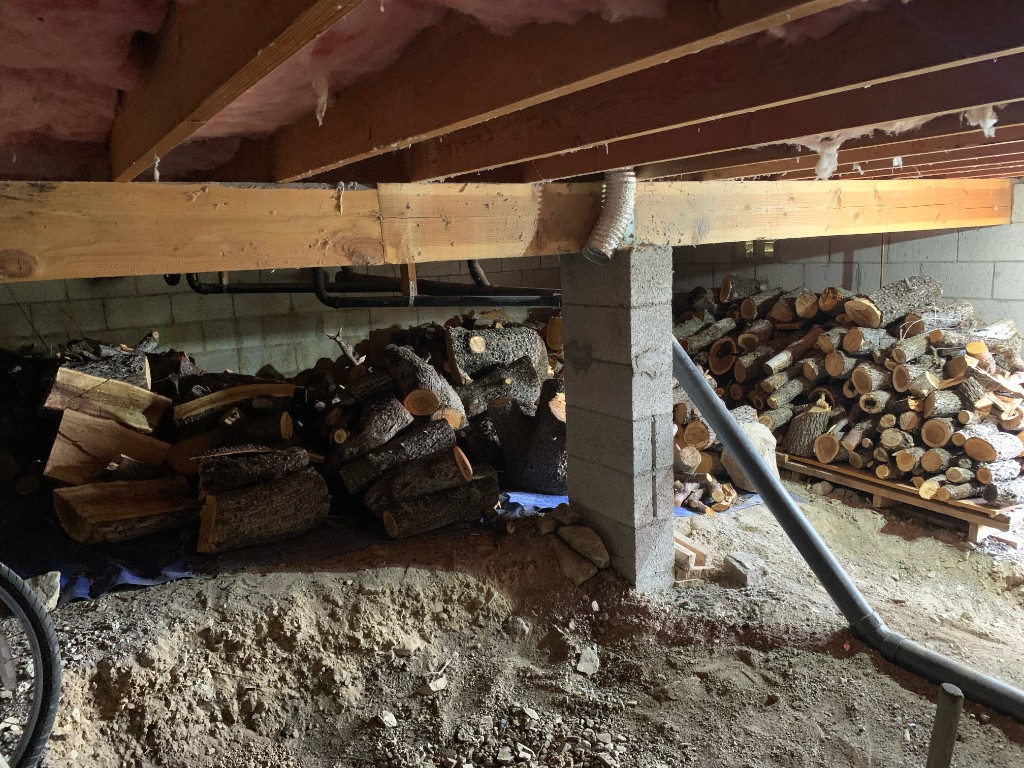 Large stacks of firewood arranged along basement walls